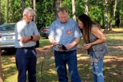 George County ARES operates Field Day each year to maintain its emergency communications capability. Other activities are also scheduled like antenna building. In the photo NI5I checks the SWR on the Spider antenna that Audria (visitor) just built. Looking on (left) is WA5MVG. (photo provided by KD4VVZ)