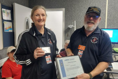 Ham Radio exists because of the service it can render.  Having the capability to pass formatted messages is one of these services.  In the photo traffic handler AE5MI receives her Official Relay Station certificate and badge from Harrison County EC WX5RJ. (photo provided by WX5RJ)