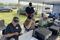 During the 2023 Mississippi QSO Party the Mississippi Coast Amateur Radio Association operated portable from the Broadwater Marina Property in Harrison County. In the photo operators from left to right are W5JGW, AG5ZH, WA5FFL, and W5SOF with AD5HS looking over their shoulders. (photo provided by N5OCT)